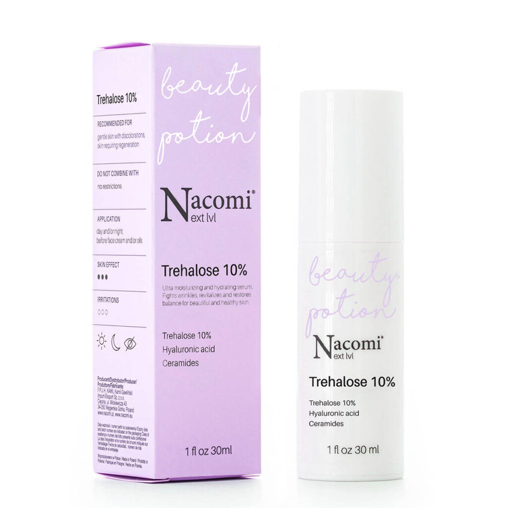Butelka serum Nacomi Trehalose 10% stoi obok fioletowego pudełka na białym tle.