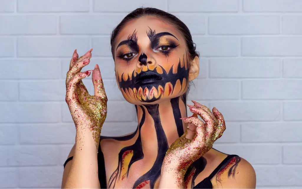 Młoda kobieta w makijażu na Halloween w czarno-pomarańczowym motywie