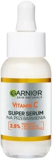 Butelka serum z pipetą Garnier stoi na białym tle, etykieta witaminy C widoczna.