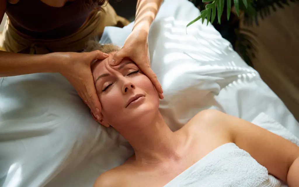 Masaż kobido wykonywany na twarzy klientki salonu kosmetycznego