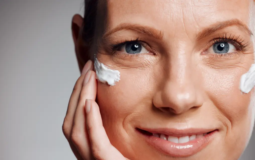 Portret dojrzałej kobiety ze zmarszczkami na twarzy i kremem pod oczami