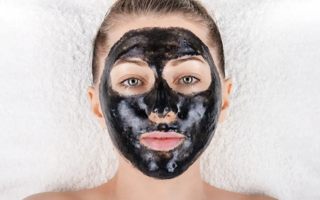 Portret młodej kobiety z czarną maseczką na twarzy z węgla aktywnego