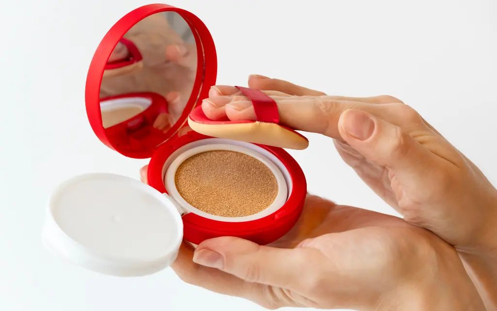 Kobiece dłonie trzymają podkład w poduszce typu cushion