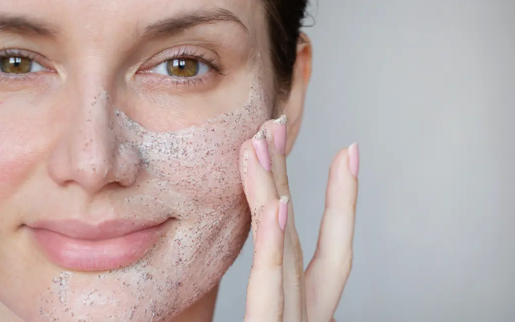 Uśmiechnięta kobieta wykonuje mechaniczny peeling twarzy złuszczający naskórek