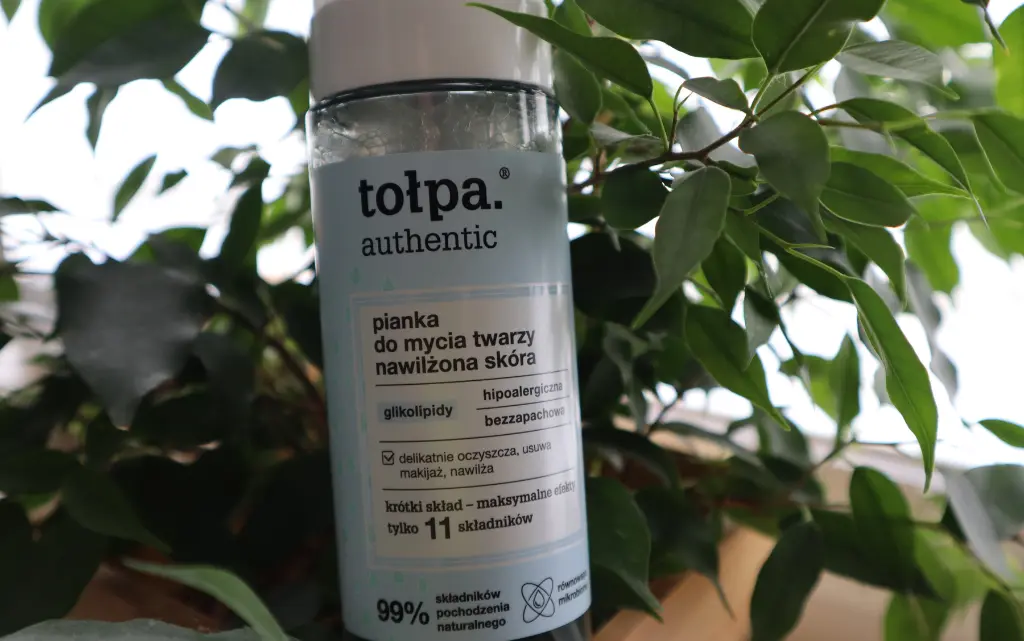 Pianka do mycia twarzy Tołpa Authentic na tle zielonego kwiatka