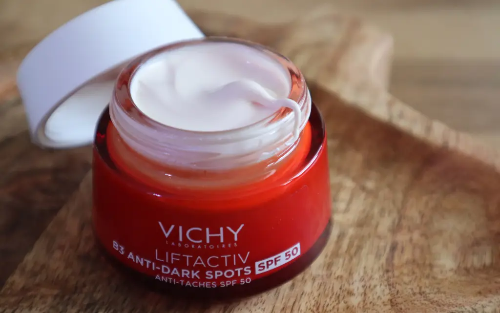 Vichy Liftactiv krem B3 SPF50 redukujący przebarwienia z otwartym słoiczkiem na tle brązowej deski dekoracyjnej