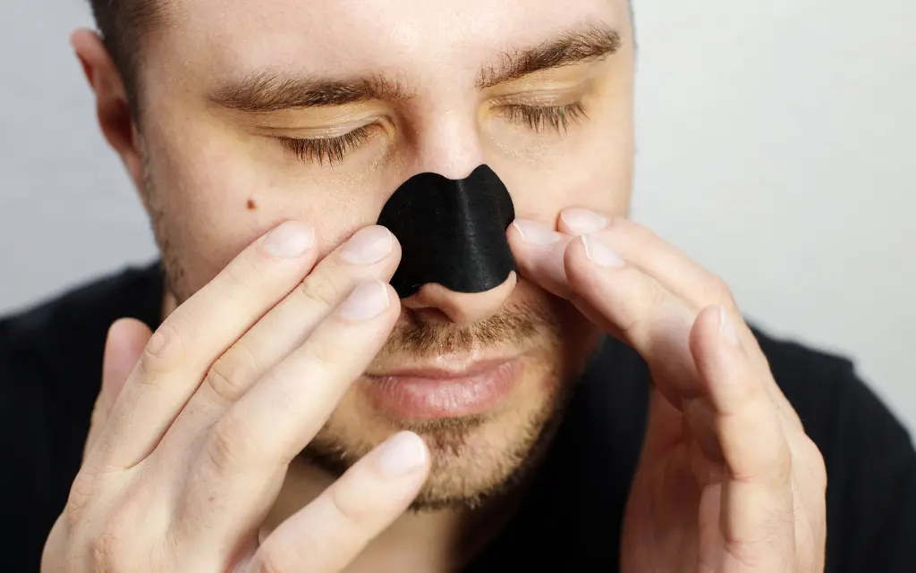 Mężczyzna używa czarnego plasterka na wągry na nosie