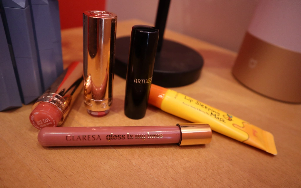 Błyszczyk Gloss is my boss marki Claresa w towarzystwie innych pomadek i masek do pielęgnacji ust
