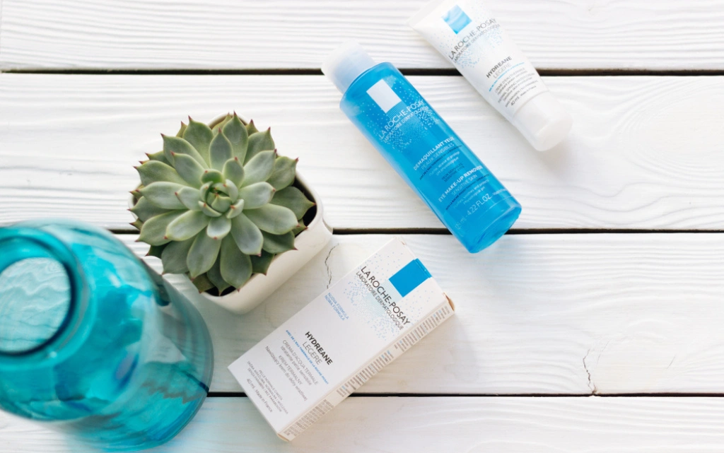 Tonik, krem i żel do mycia twarzy marki La Roche Posay, obok zielony sukulent i niebieski wazon