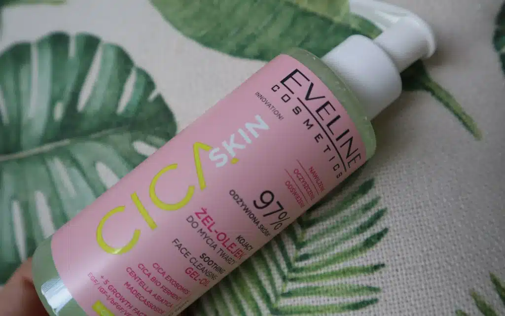 Opakowanie Eveline żel-olejek do mycia twarzy Cica skin na tle beżowo zielonej poduszki