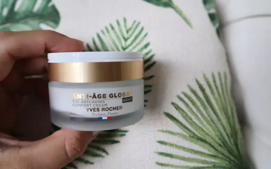 Kobieca dłoń trzyma krem na zmarszczki Yves Rocher Anti-Age Global na noc