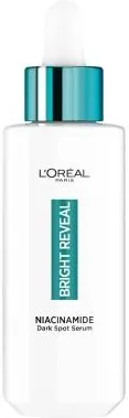 Buteleczka serum L'Oréal prezentuje zakraplacz, etykietę "Bright Reveal" z niacynamidem, na białym tle.