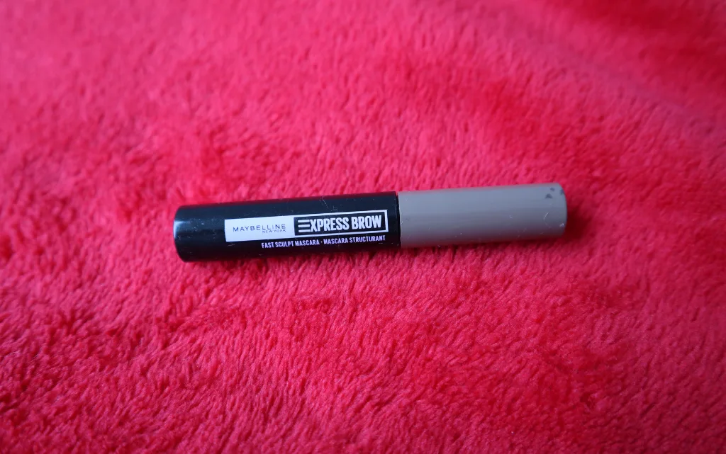 Maskara do brwi Maybelline NY Express brow Sculpt na tle czerwonego kocyka