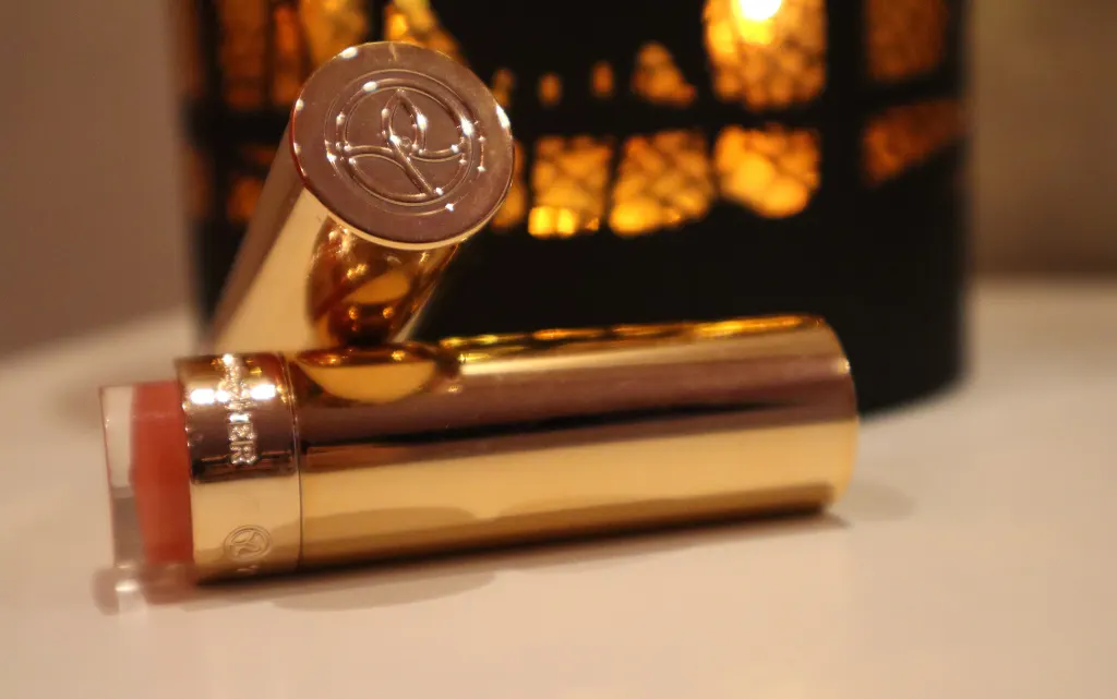 Pomadki do ust Yves Rocher Grand Rouge na tle jesiennej lampki