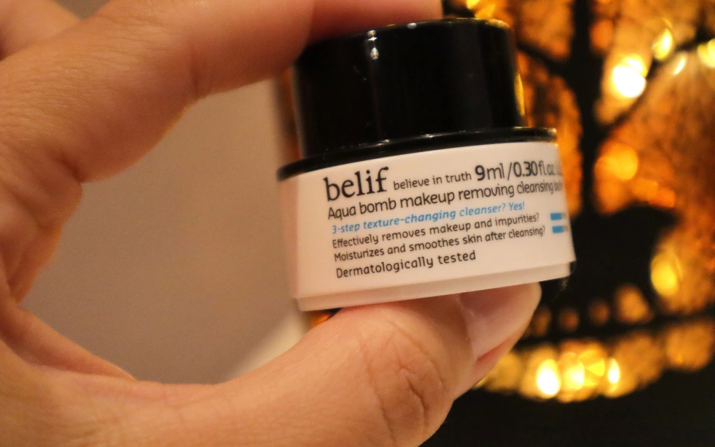 Kobieca ręka trzymają próbkę mydełka do demakijażu Belif Aqua Bomb