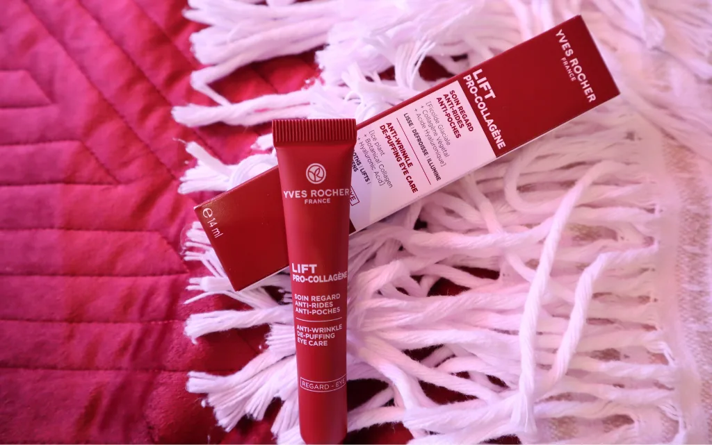 Przeciwzmarszczkowy krem niwelujący worki pod oczami Yves Rocher lezący na narzucie na łóżku