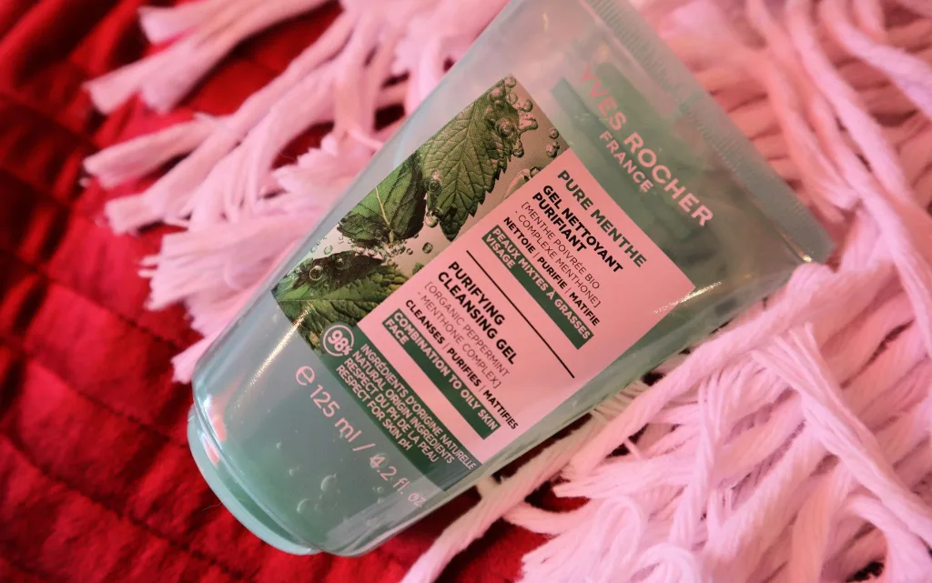Opakowanie żelu oczyszczającego z miętą pieprzową Yves Rocher leżące na łóżku