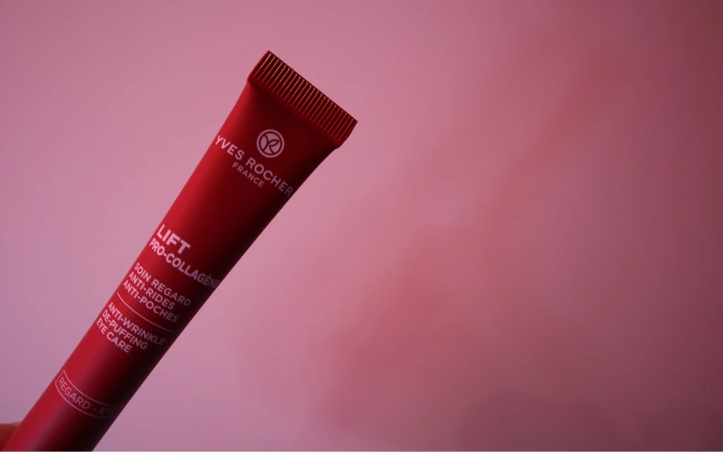 Przeciwzmarszczkowy krem niwelujący worki pod oczami na tle czerwonej ściany