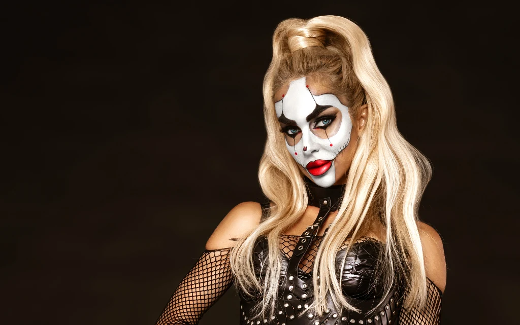 Młoda kobieta w stroju i makijażu seksownego klauna na Halloween