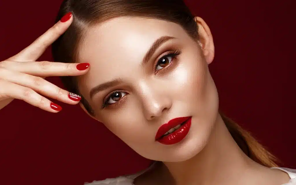 Młoda kobieta w mocnym makijażu wieczorowym z czerwonymi ustami