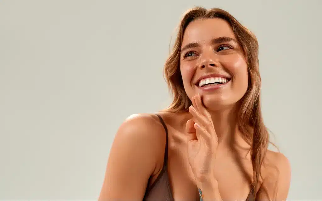 Uśmiechnięta, młoda kobieta z makijażem rozświetlającym