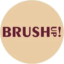 Napis "BRUSHup!" ciemnoczerwony, wyśrodkowany i wytłuszczony na okrągłym beżowym tle.