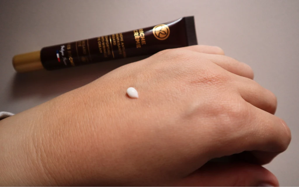 Kropelka kremu pod oczy na kobiecej dłoni Yves Rocher Riche Crème