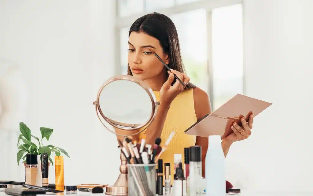 Kobieta w biurze wykonuje makijaż biznesowy do sesji fotograficznej