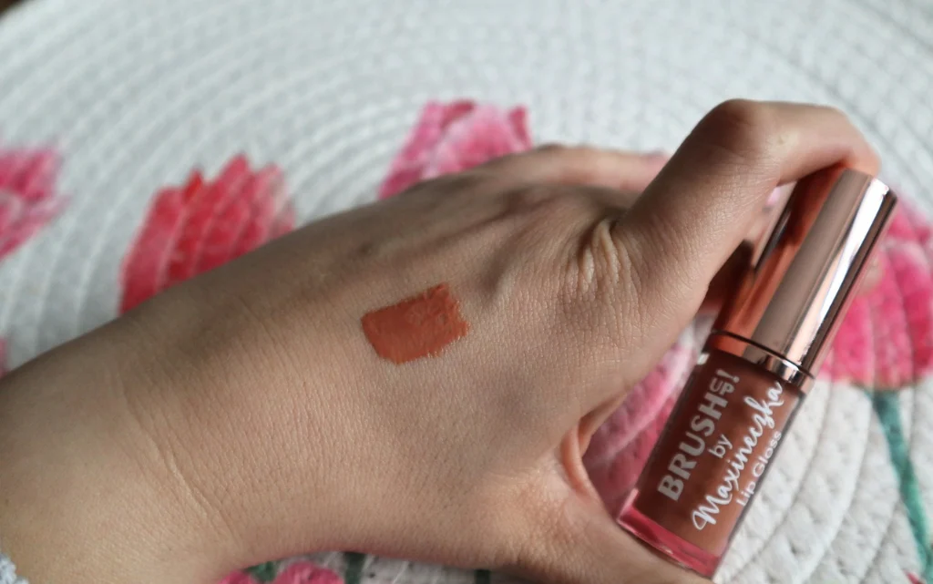 Kolor błyszczyka Brushup! by Maxineczka 03 Caramel Nude na kobiecym nadgarstku