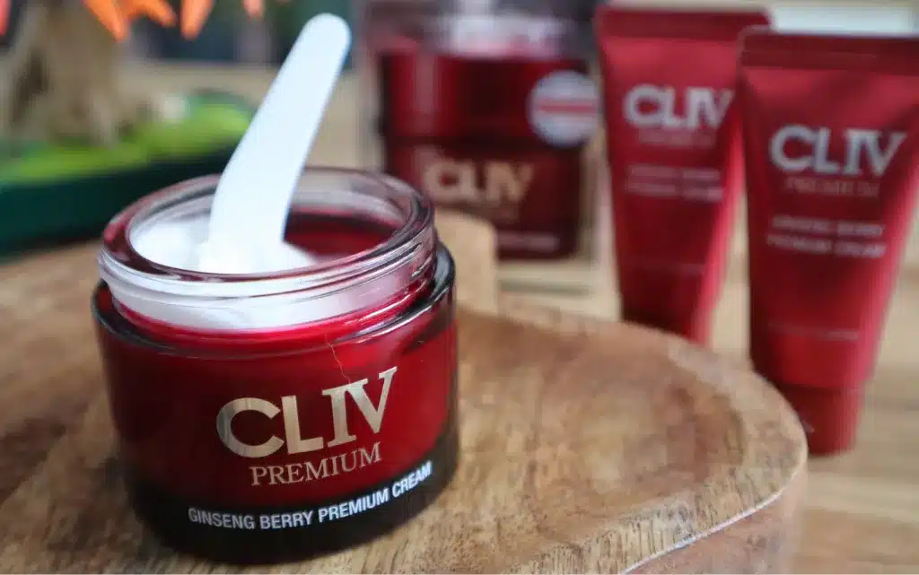 Otworzone opakowanie odżywczo-ujędrniającego kremu do twarzy Cliv premium, w tle dwie małe próbki 10 ml