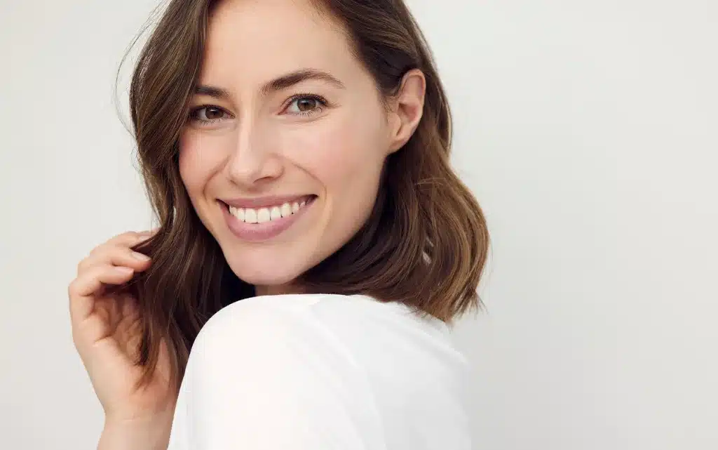 Kobieta z lekkim i świeżym makijażem, z odrobiną różu na policzkach