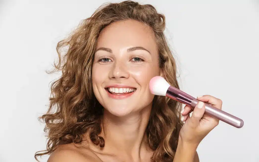 Kobieta rozcierająca róż puszystym pędzlem