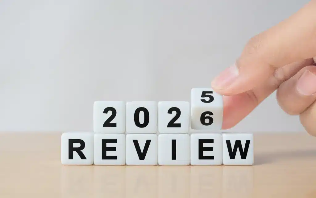 Kobieca dłoń zmienia kostkę na napisanie Review 2025 na 2026