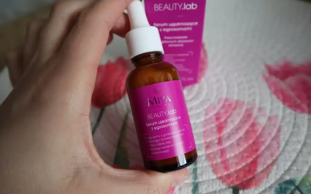 serum ujędrniające z egzosomami Miya Cosmetics BEAUTY.lab w kobiecej dłoni na tle dekoracyjnej podkładki