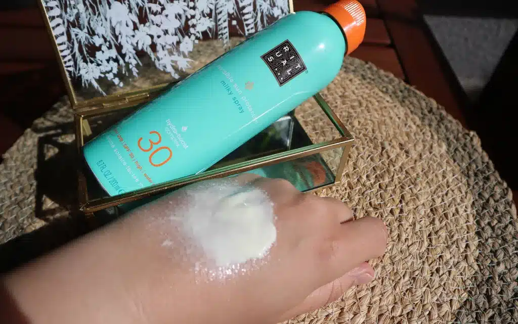 Test na kobiecej dłoni mleczka do opalania w sprayu The Rituals of Karma SPF 30