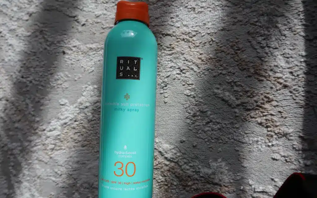 Mleczko do opalania w sprayu The Rituals of Karma SPF 30 na szarym tle