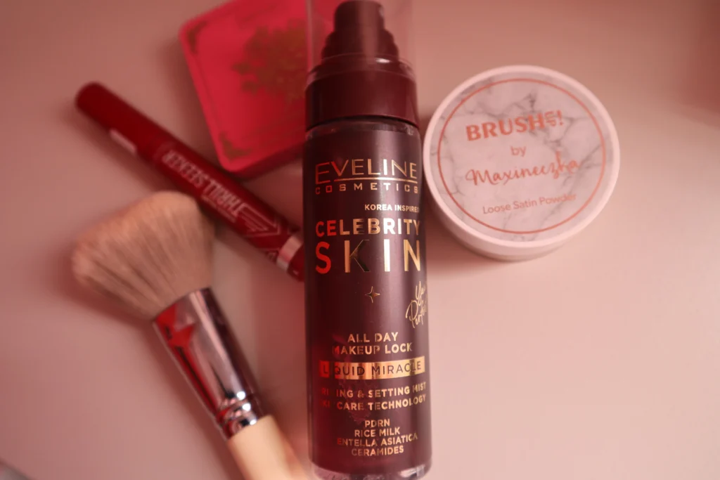 Mgiełka do makijażu Eveline Celebrity Skin na tle pudru, cieni do powiek, tuszu i pędzla do makijażu