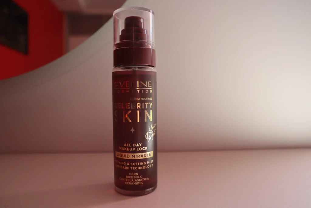 Mgiełka do makijażu Eveline Celebrity Skin na tle beżowej ściany