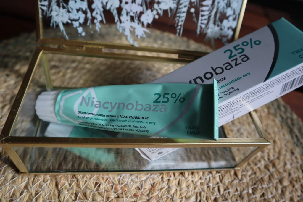 Krem w aluminiowej tubce Niacynobazy 25% na tle szkatułki dekoracyjnej