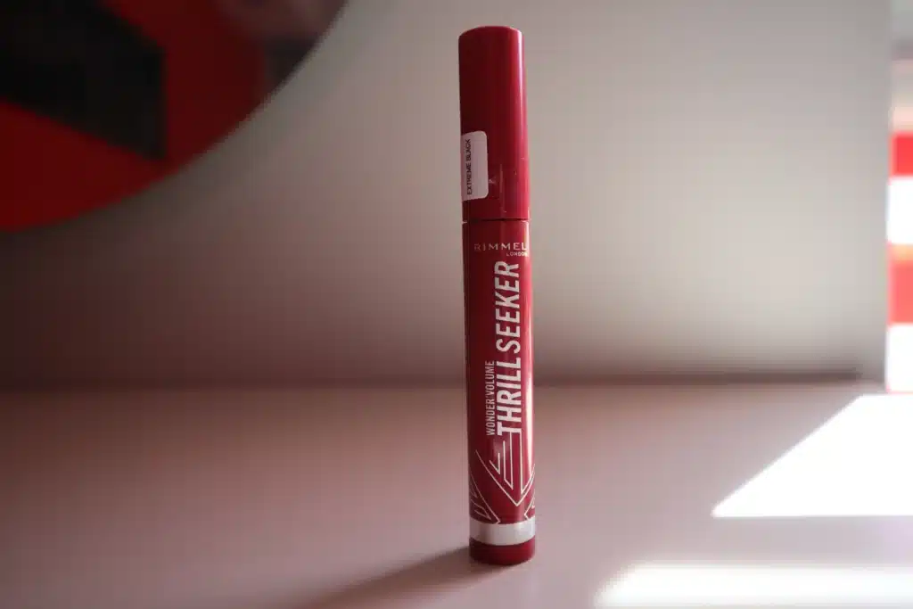 Rimmel Volume Thrill Seeker wydłużający i zwiększający objętość tusz do rzęs na tle szarej ściany