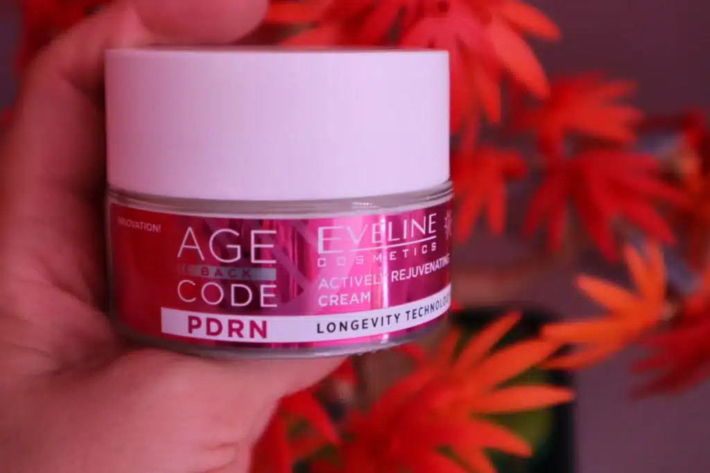 Eveline Cosmetics Age Back Code Krem do twarzy, aktywnie odmładzający, na dzień i na noc  trzymany w kobiecej dłoni 