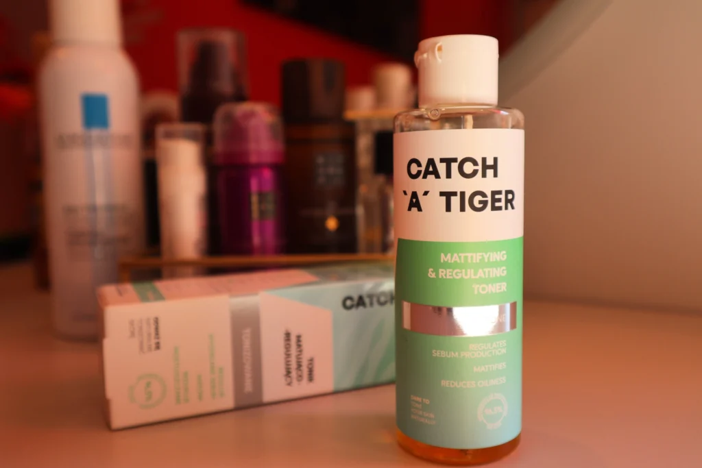 Catch a Tiger Tonik matująco-regulujący na toaletce, w tle inne kosmetyki