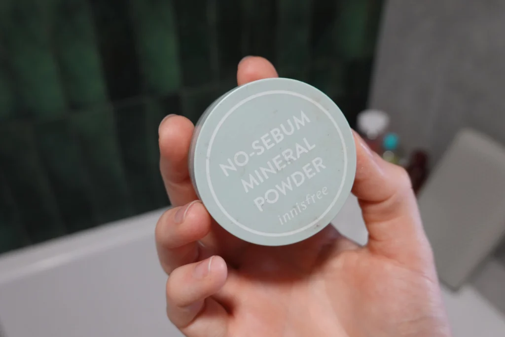 Innisfree No Sebum Mineral Powder trzymana przez kobiecą dłoń