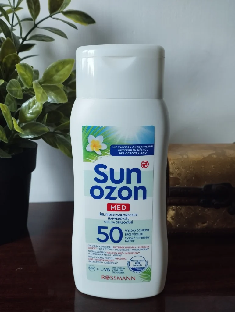 Sunozon Med Żel przeciwsłoneczny na komodzie, w tle roślinka i szkatułka na biżuterię