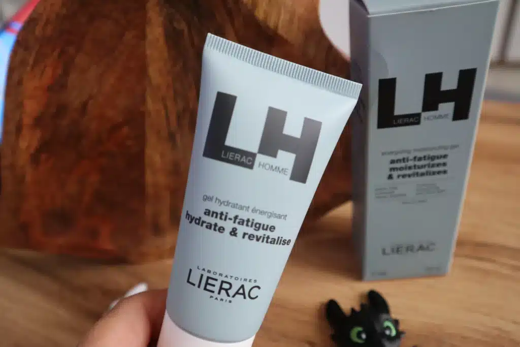 Lierac Homme LH trzymany w dłoni na tle opakowania – test kosmetyku dla mężczyzn