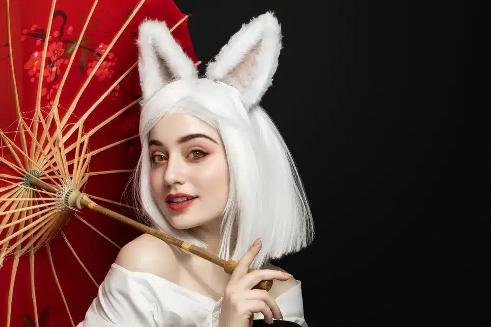 Stylizacja cosplay z białą peruką i futrzanymi uszami — makijaż w ciepłych różach, bez kocich wąsów i nosa 