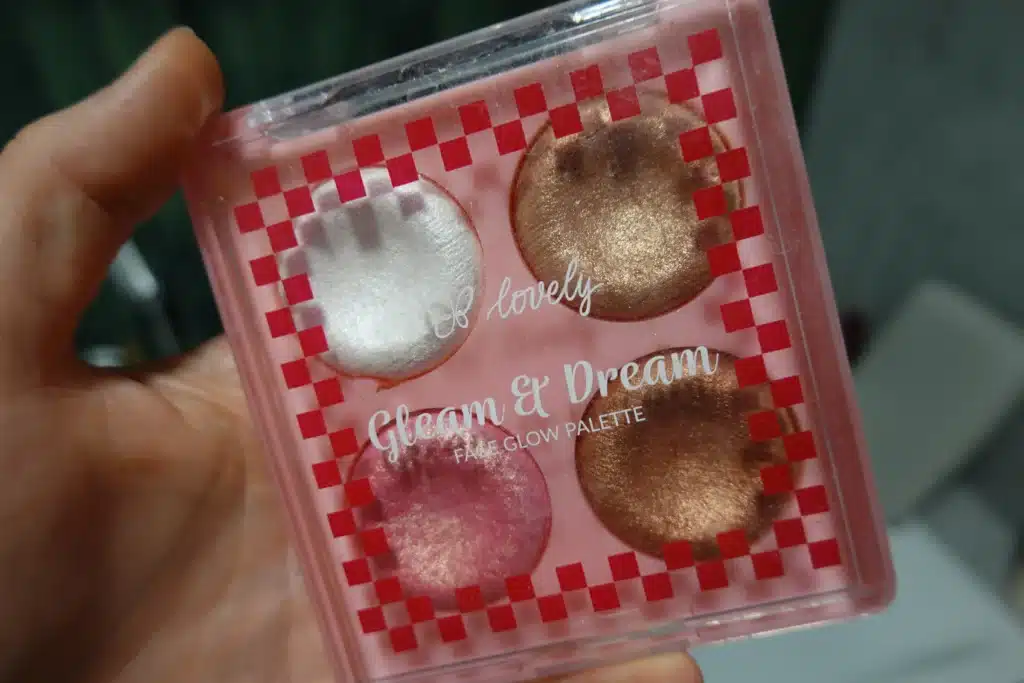 Lovely Gleam & Dream Face Glow Palette paleta rozświetlaczy do twarzy i ciała trzymana w kobiecej dłoni